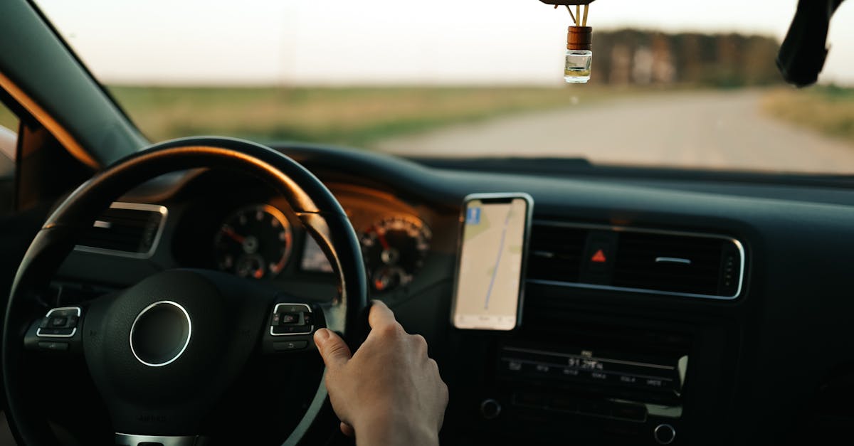 Interior of a car with GPS navigation, focusing on the driver and dashboard during the day.